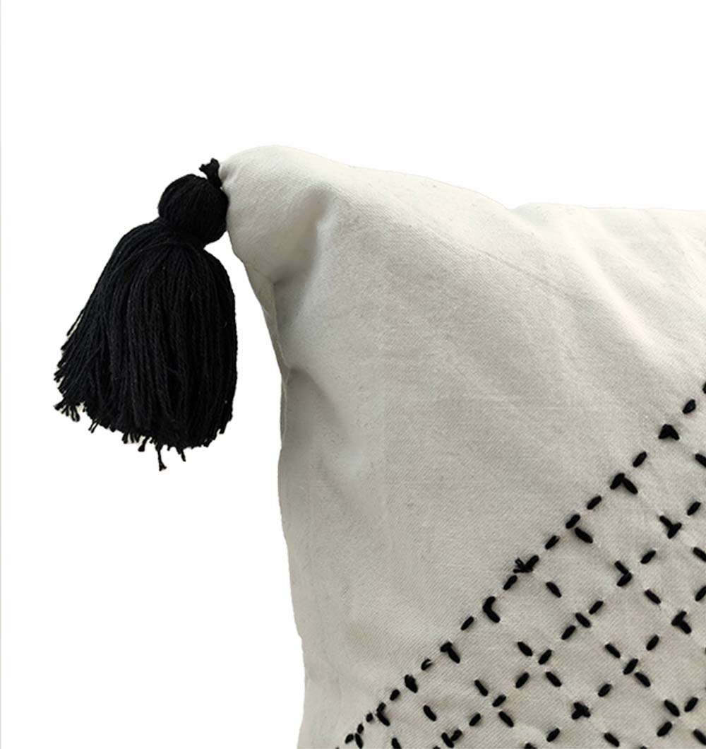 The RAMSHA HOME Embroidery White And Black Cotton Cushion With Tassel CS-194 features black stitched patterns and a black tassel on one corner, shown in close-up against a plain white background.
