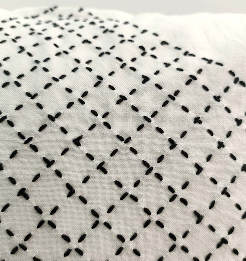 The RAMSHA HOME Embroidery White And Black Cotton Cushion With Tassel CS-194 features hand-embroidered black geometric patterns on soft cotton—a stylish, elegant accent for your décor.