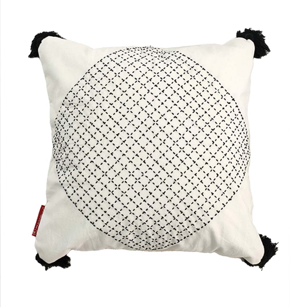 The RAMSHA HOME Embroidery White And Black Cotton Cushion With Tassel CS-194 features a white cotton base, bold black embroidered intersecting circles at the center, corner tassels, and a red tag—ideal for chic home décor.