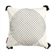 The RAMSHA HOME Embroidery White And Black Cotton Cushion With Tassel CS-194 features a white cotton base, bold black embroidered intersecting circles at the center, corner tassels, and a red tag—ideal for chic home décor.