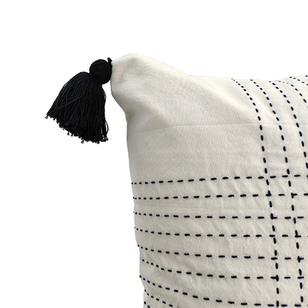 The RAMSHA HOME Embroidery White And Black Cotton Cushion With Tassel CS-192 features a stylish grid of black stitched lines and a tassel on one corner, adding modern flair to any space.
