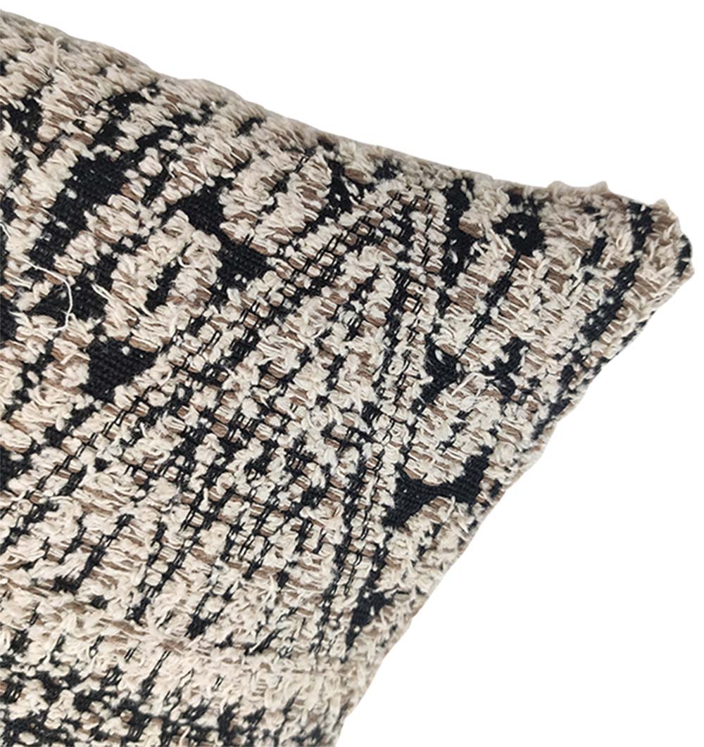 Close-up of the RAMSHA HOME Boho Cushion With Small Tassels CS-204, featuring a beige and black woven geometric pattern, textured cotton surface, and abstract design, shown at one corner against a white background.