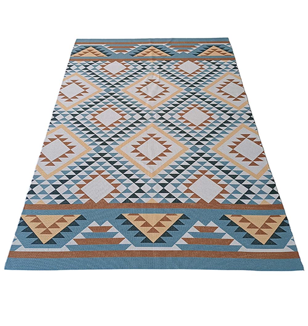 The RAMSHA HOME Geometric Diamond Tribal Blue & Tan Rug – DD 016 showcases a geometric pattern of diamonds and triangles in blue, beige, brown, and white, arranged in horizontal rows.