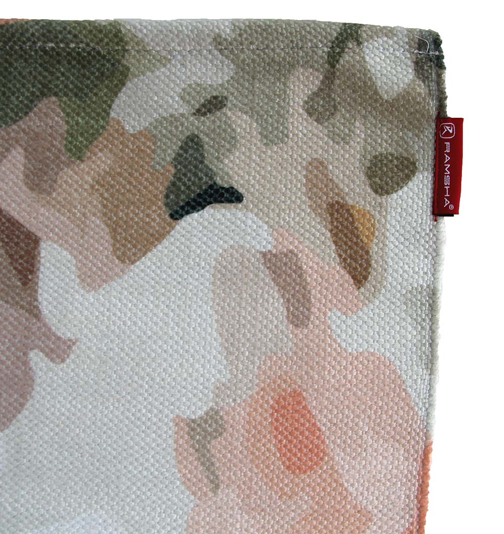 A close-up of the RAMSHA HOME Polyester Multi Color Printed Rug 150x210 cm DD-030 shows an abstract, camouflage-like pattern in earthy tones and a red woven label with white text sewn onto the upper right edge.