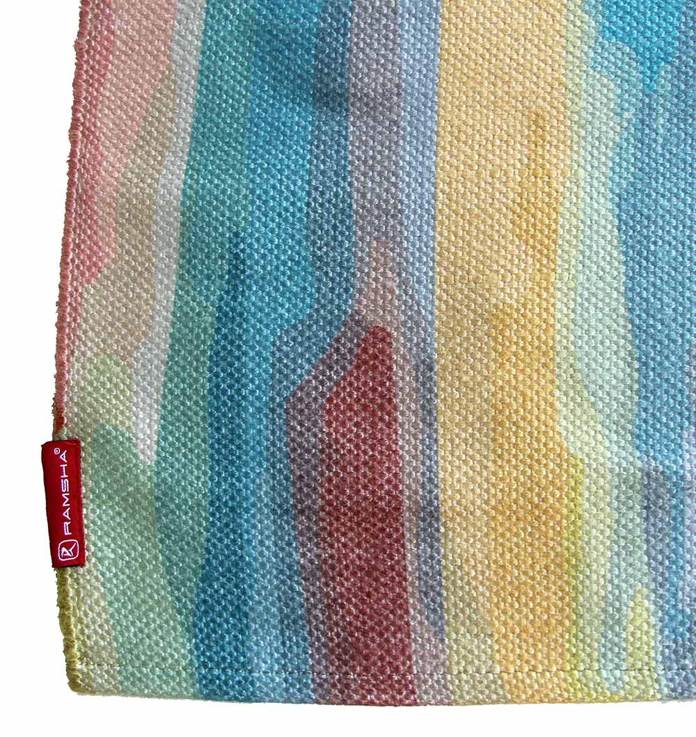 A close-up of the RAMSHA HOME Digital Printed Rug Multi Color 150X210 cm (DD-036) displays vertical stripes in blue, green, yellow, red, and beige tones with a visible red RAMSHA label on the edge.