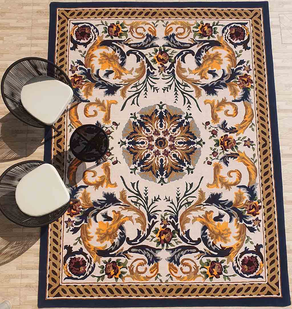 The RAMSHA HOME Polyester & Cotton Hall Decor Rug - HTP 02 (300x400cm) features an ornate, symmetrical floral and swirl design in gold, navy, red, and green. Two modern black chairs with white seats sit at the rug’s upper left corner.