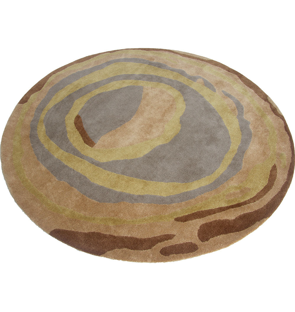 The RAMSHA HOME Multi Color Round Polyester & Cotton Carpet HTP-07 features a hand-tufted swirl pattern in brown, beige, tan, and gray, evoking natural wood grain or tree rings for a neutral accent.