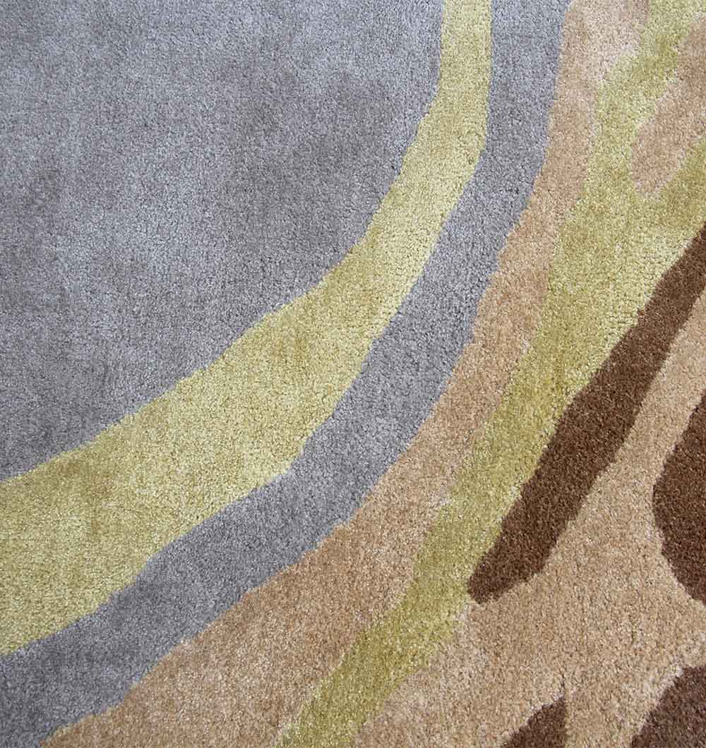 Close-up of the RAMSHA HOME Multi Color Round Polyester & Cotton Carpet HTP-07, featuring hand tufted curved bands in gray, beige, yellow, and brown—a modern abstract rug ideal for adding a neutral touch to contemporary spaces.