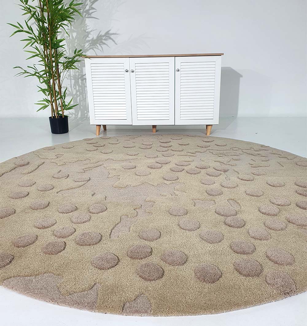 The RAMSHA HOME Round Home Decor Handmade Carpet – HTW-56, featuring raised circular patterns, is placed in front of a white shutter-door cabinet with a potted bamboo plant nearby on the light-colored floor.