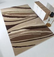 The Striking Pattern Home Decor Handmade Carpet – HTW-61 by RAMSHA HOME, featuring brown, beige, and cream wavy lines, lies on a white floor near a wooden cabinet and a gold side table with a black lamp.