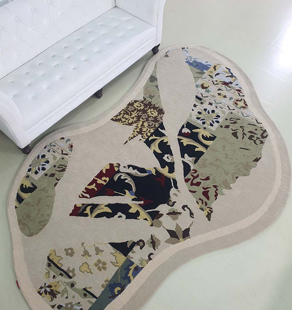 The RAMSHA HOME Unique Unshaped Handmade Carpet For Home Decor HTW-70 with a beige border and multicolored floral patchwork accents lies on a light floor beside a white tufted sofa.
