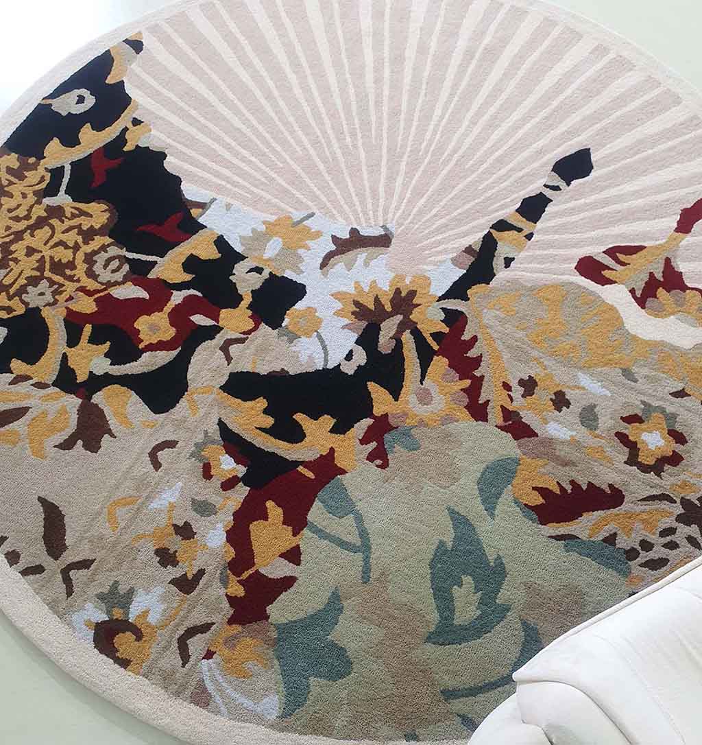 The RAMSHA HOME Round Multi Area Rug HTW-73 (200 cm), a hand-tufted rug with an abstract floral pattern in beige, yellow, black, red, and green, is placed on a light floor beside white furniture.