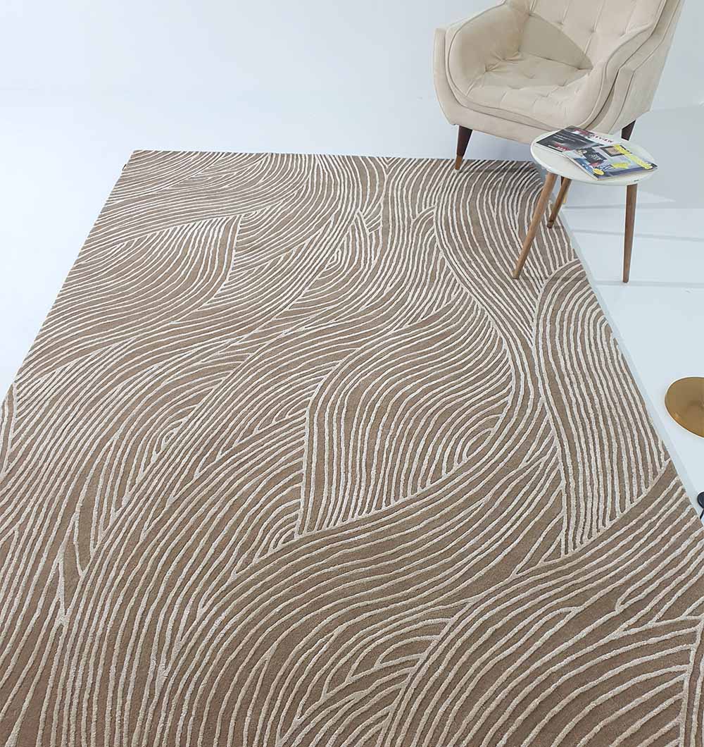 The RAMSHA HOME Handmade Beige Handtufted Area Rug HTWV-53, featuring abstract wavy lines, adds warmth and texture to a minimalist room with a cream armchair and round side table holding magazines.