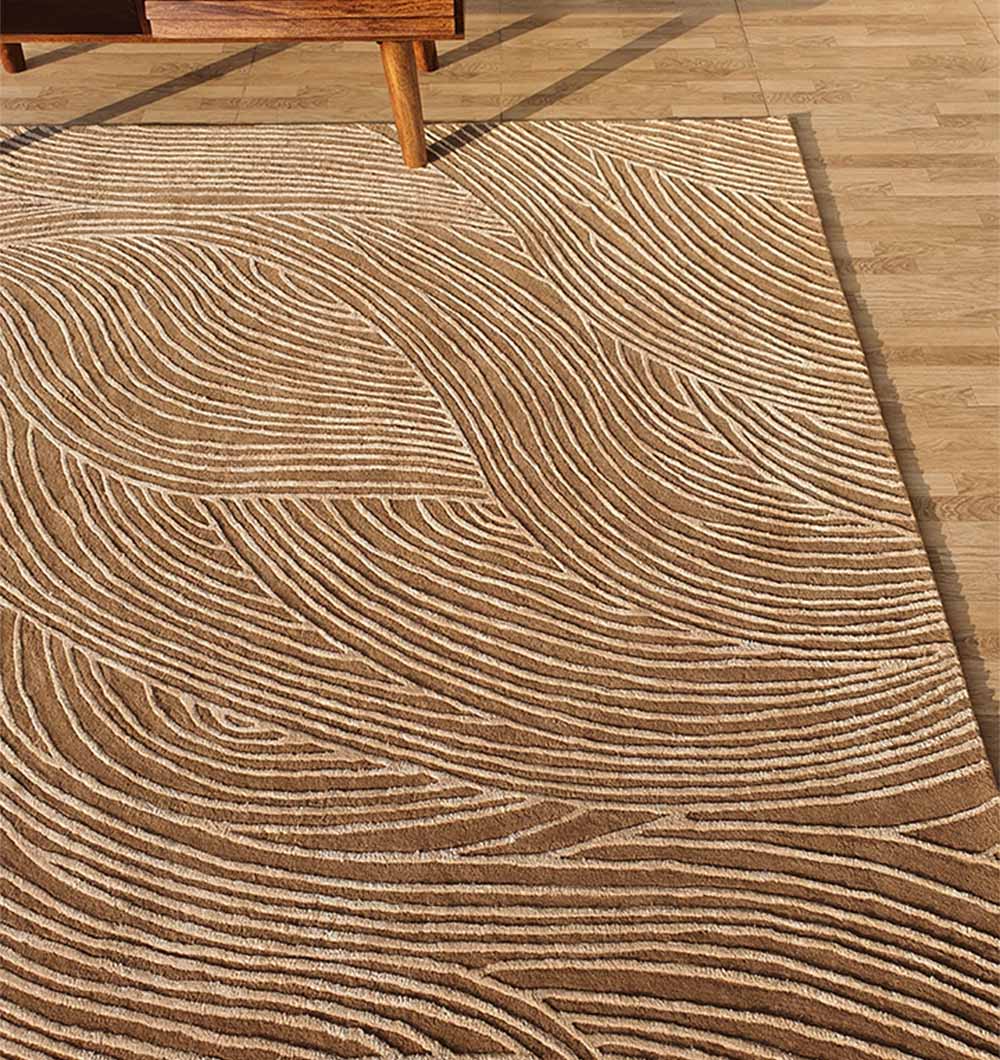 The RAMSHA HOME Handmade Beige Handtufted Area Rug HTWV-53 features a light brown base with cream abstract curves, shown on a wooden floor beside wooden furniture.