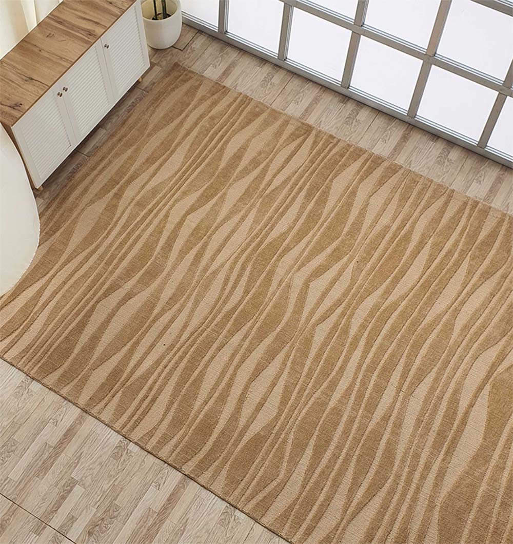 The RAMSHA HOME Rectangle Beige Color Carpet MNR-03, featuring subtle wavy stripes, is placed on a light wood floor near a cabinet and potted plant by floor-to-ceiling windows.