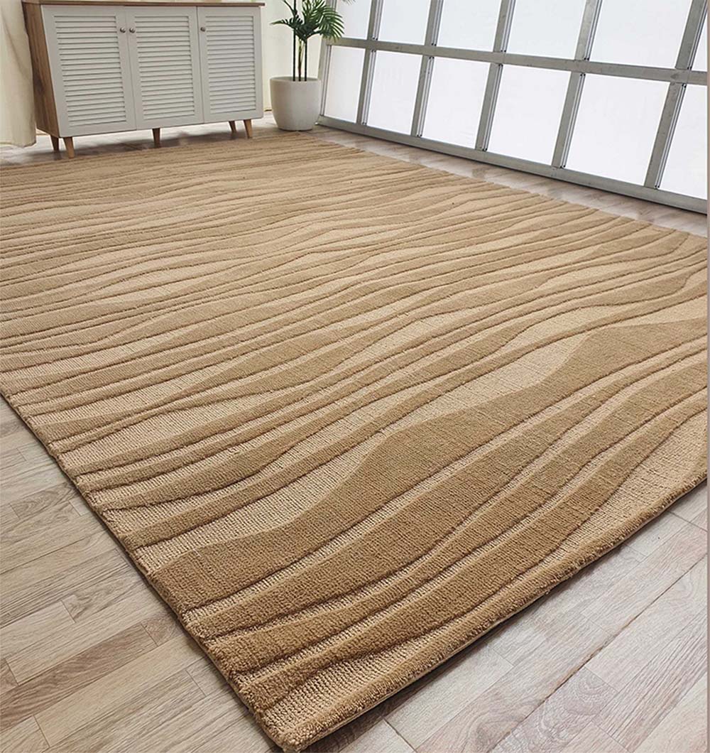 The RAMSHA HOME Rectangle Beige Color Carpet MNR-03 lies on a light wood floor by a sideboard, potted plant, and tall windows that brighten the room. Its abstract textured design adds style to the space.