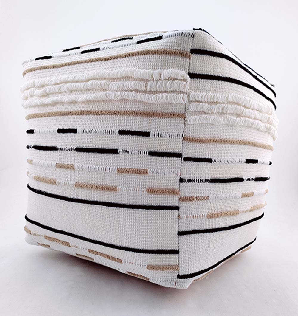The RAMSHA HOME Cotton Boho Pouf PF-066 is a cube-shaped cushion with white woven fabric and black and beige stitched lines, creating a geometric boho look—ideal as a versatile accent for modern spaces.