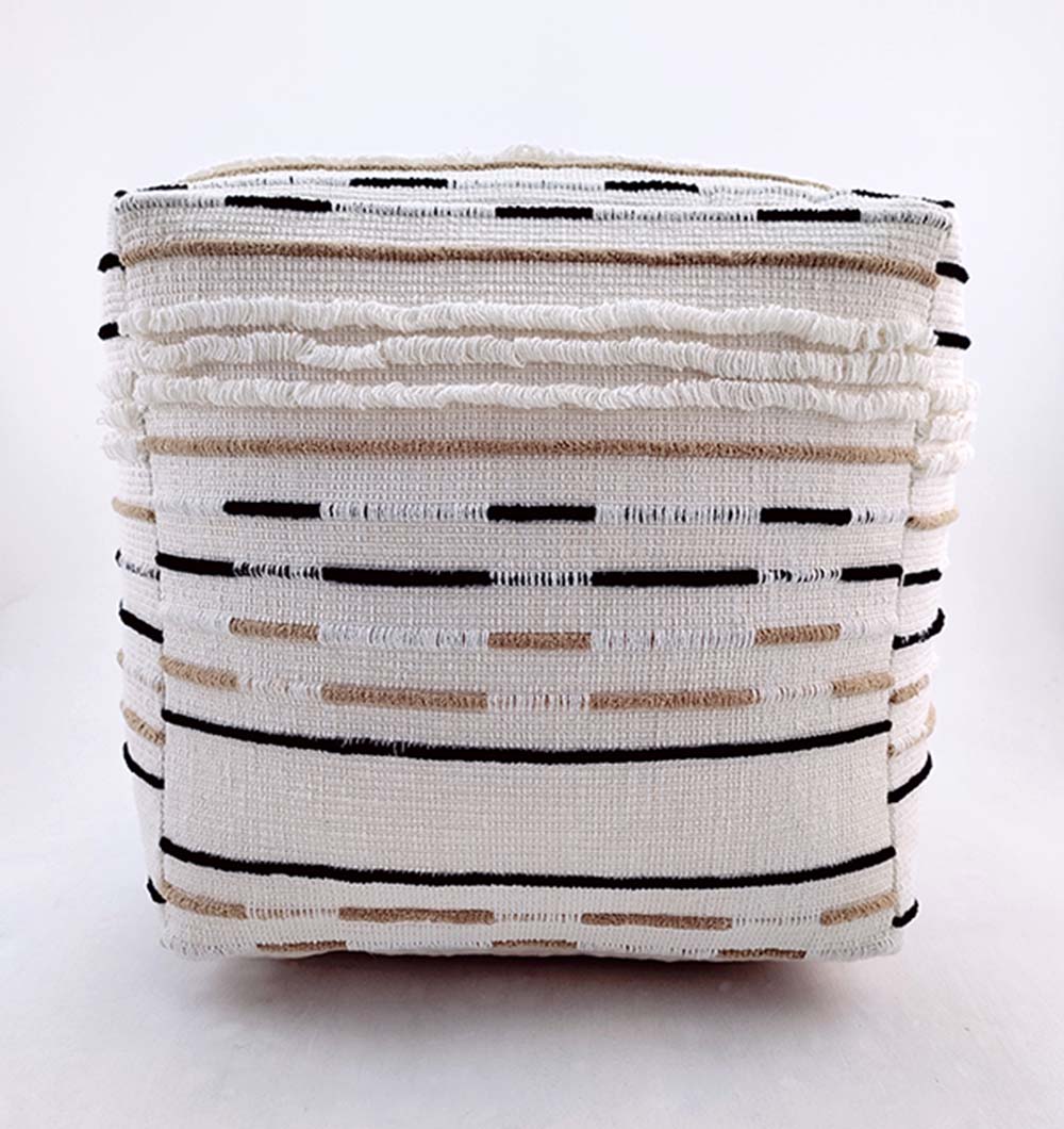 The RAMSHA HOME Cotton Boho Pouf PF-066 is a square, white ottoman with black, beige, and brown textured horizontal stripes. Its cotton fabric combines smooth and fringed details for a modern, minimalist boho style.