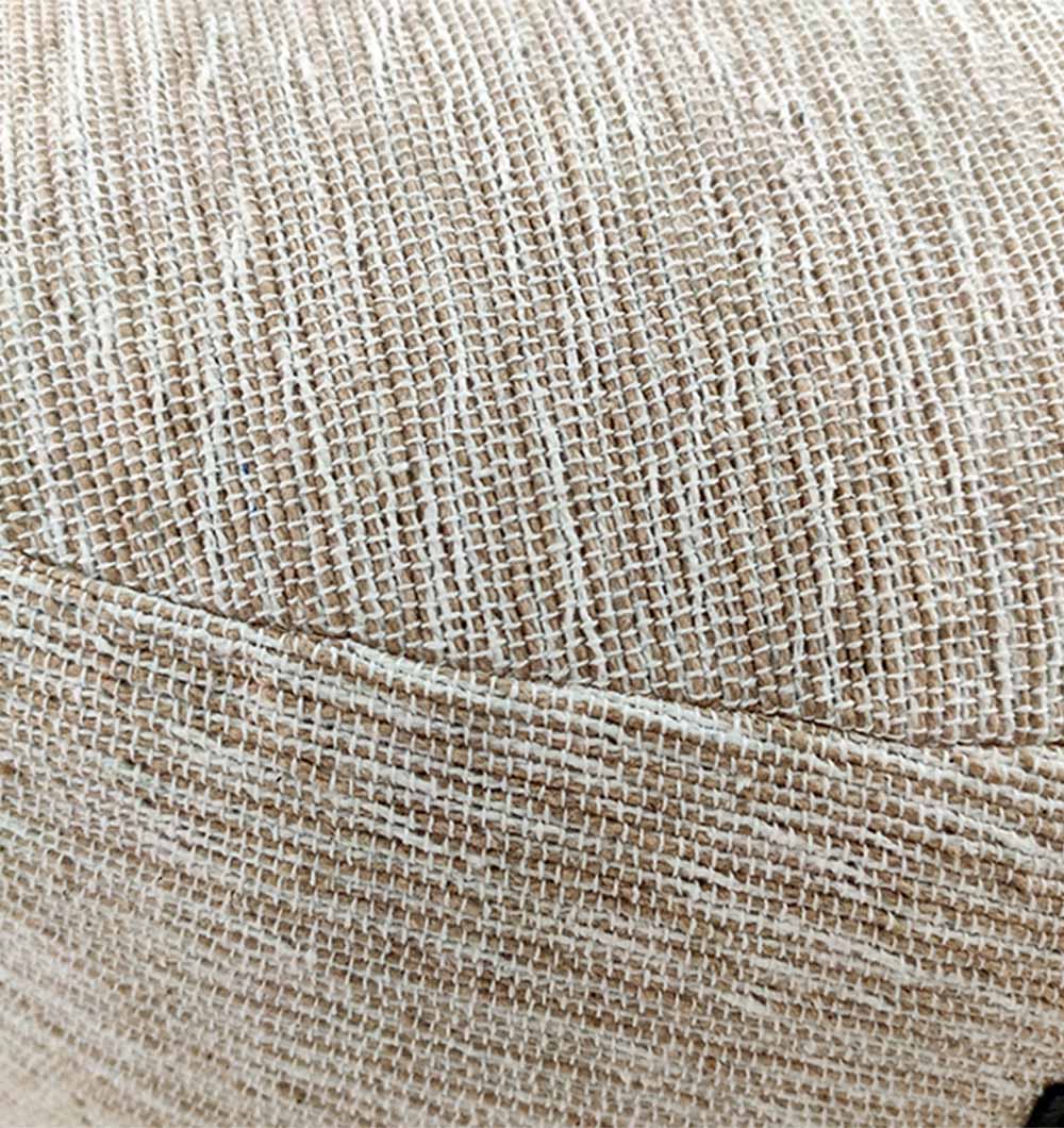 Close-up of white-beige pouf showing soft 100% cotton woven texture