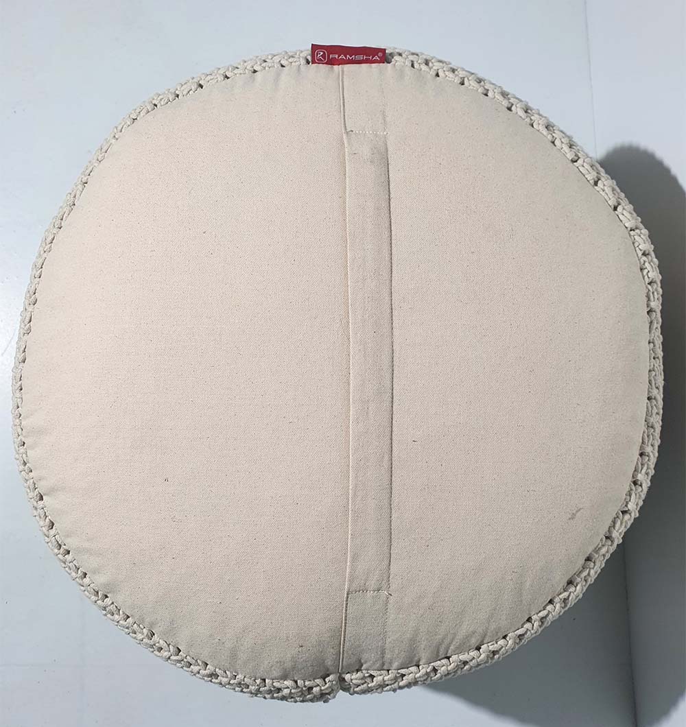 The RAMSHA HOME Round Cotton Pouf PF-072 features braided edges, a center fabric handle, and a small red label near the top. Seen from above on a light surface, it's ideal for cozy seating or home décor.