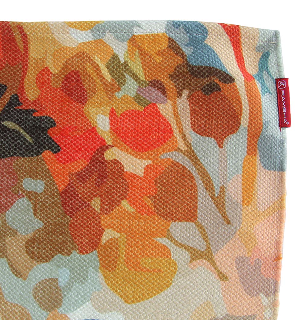A close-up of the RAMSHA HOME Polyester Digital Printed Multi Color Rug DD-034, showcasing its vibrant abstract floral pattern in orange, red, brown, and blue hues, with a small rectangular red label sewn on the edge.