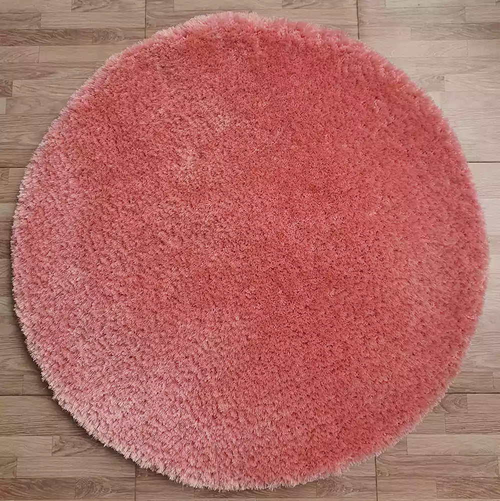 The RAMSHA HOME Round Shaped Pink Shaggy Rug - SG 01, featuring a plush pile, is placed on a light brown wooden floor.