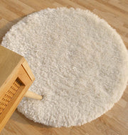 The RAMSHA HOME Decorative Shaggy Rug White Color - SG-012 features a round, plush design with thick pile, adding cozy comfort and modern style to any light wood floor next to furniture with woven accents.