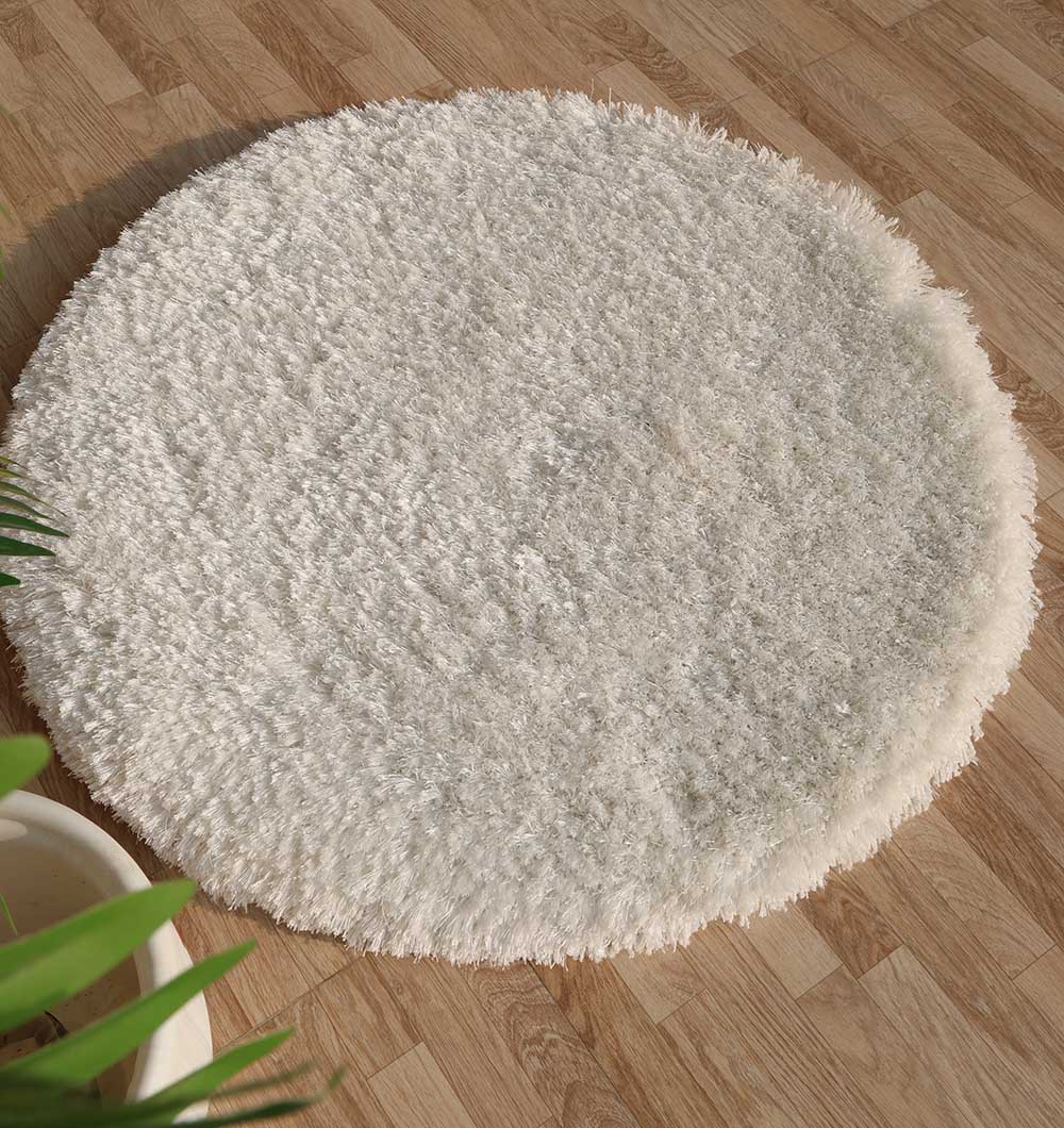 A RAMSHA HOME Decorative Shaggy Rug White Color (SG-012), with a plush, thick pile and shag finish, lies on a light wood floor. Its soft texture is highlighted as a green plant appears in the bottom left of the image.