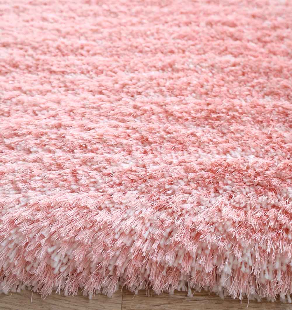 Close-up of the RAMSHA HOME Pink Home Decor Shaggy Rug - SG 01 on a wooden floor, featuring thick, soft fibers that give this rectangular rug a cozy and plush look.