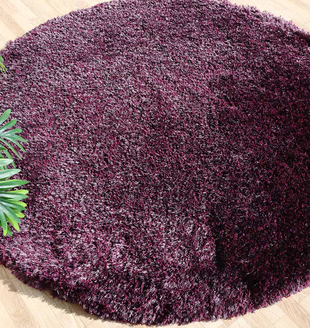 The RAMSHA HOME Shaggy Rug for Living Room - SG 019, featuring a plush, textured pile in deep purple and maroon, sits atop a wooden floor with a green plant partially visible at the edge.