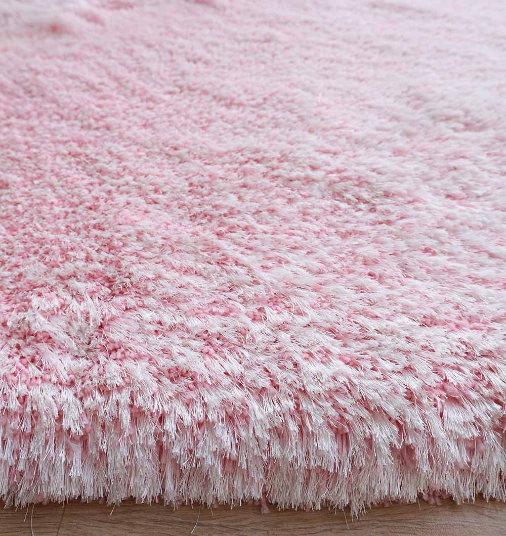 Close-up of the RAMSHA HOME Light Pink Color Dining Room Shaggy Rug - SG 02, showcasing its soft, fluffy pile and thick shaggy fibers as it rests elegantly on a wooden floor.