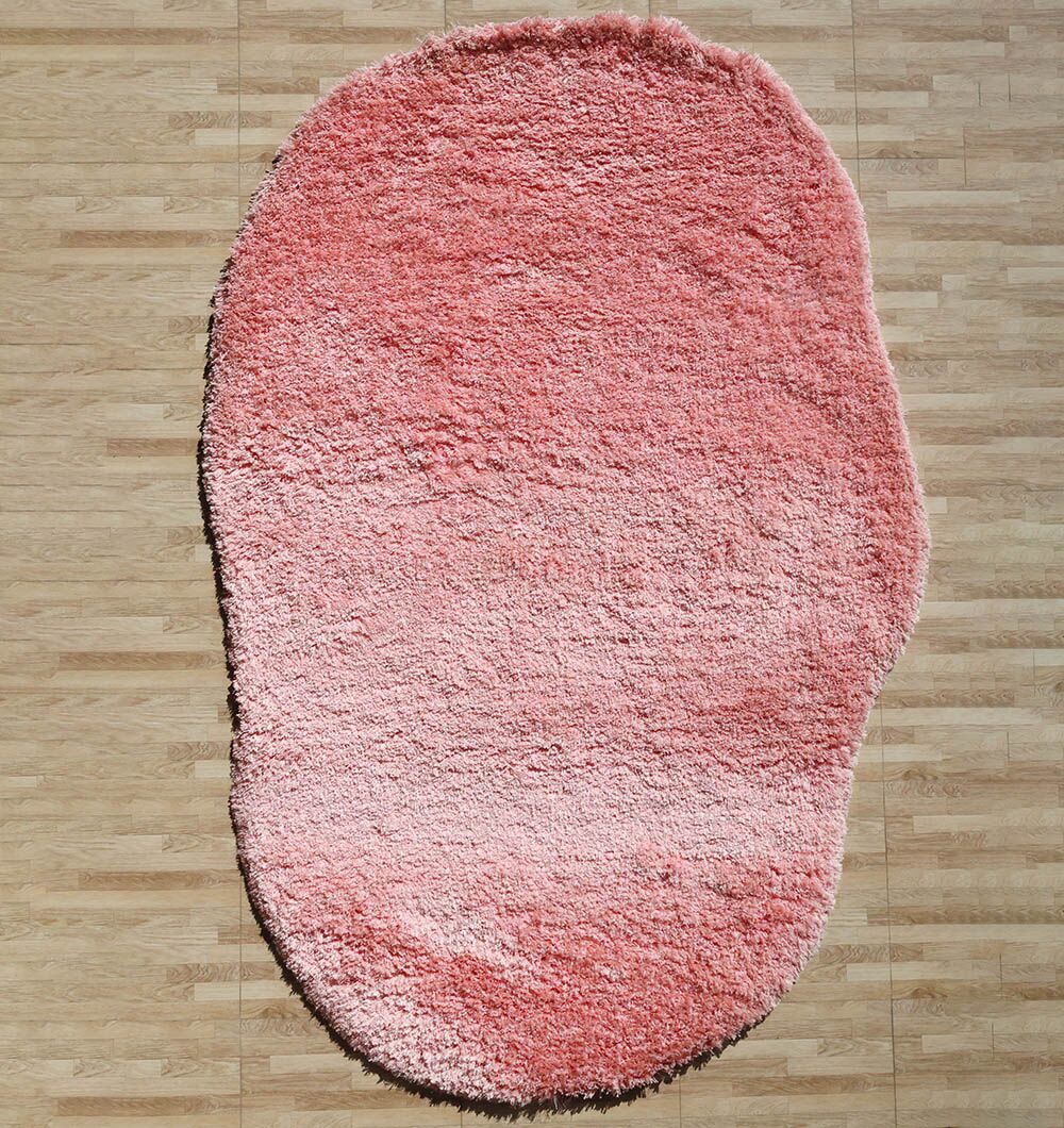 The RAMSHA HOME Shaggy Shape Rug for Living Room (SG 027-A, 200x300 cm) in pink features plush texture and uneven edges, adding cozy character to a light wood floor.