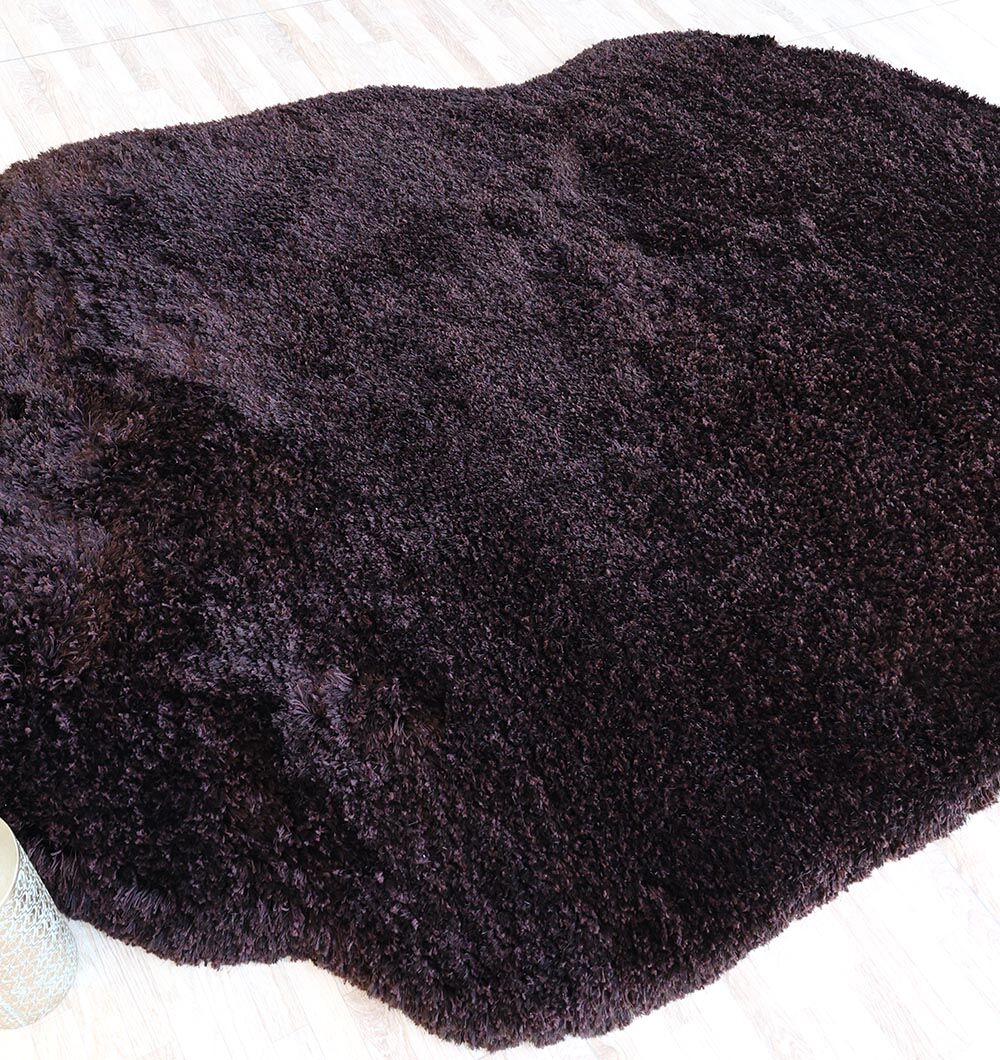 The RAMSHA HOME Dark Brown High-Density Shaggy Rug (SG 028), with its fluffy, organic shape, creates a cozy accent against the light wood floor.