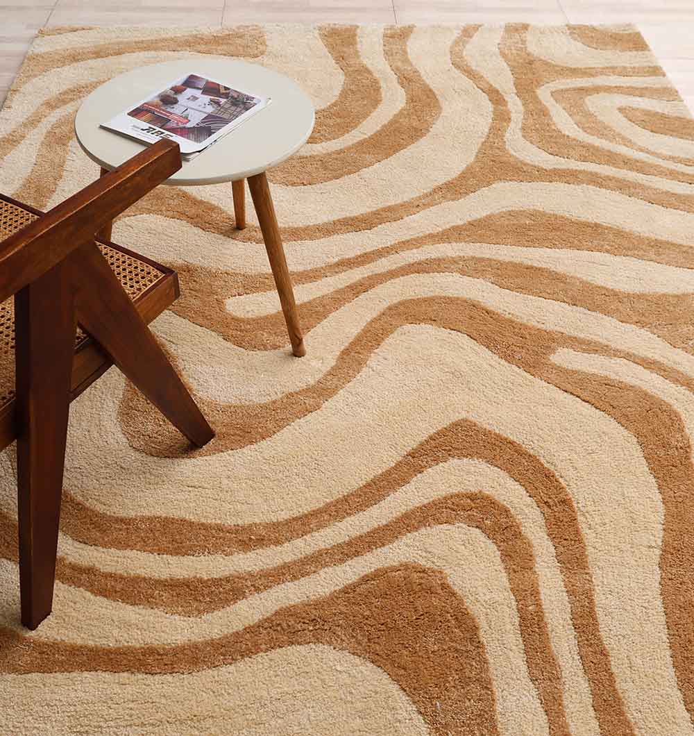 The RAMSHA HOME Rectangle Beige & Brown Color Shaggy Rug (SG 032, 200x300 cm) adds cozy texture beneath a wooden chair and round side table, with its wavy abstract stripes enhancing the living room’s warmth.