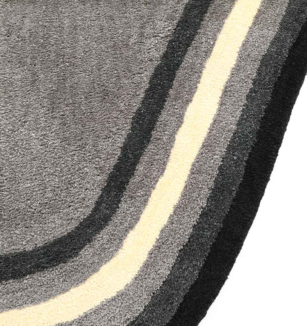 Close-up of the RAMSHA HOME Shaggy Rug for Living Room - SG 037 (160x230 cm), showing curved stripes in dark gray, light gray, cream, and white on a light background.