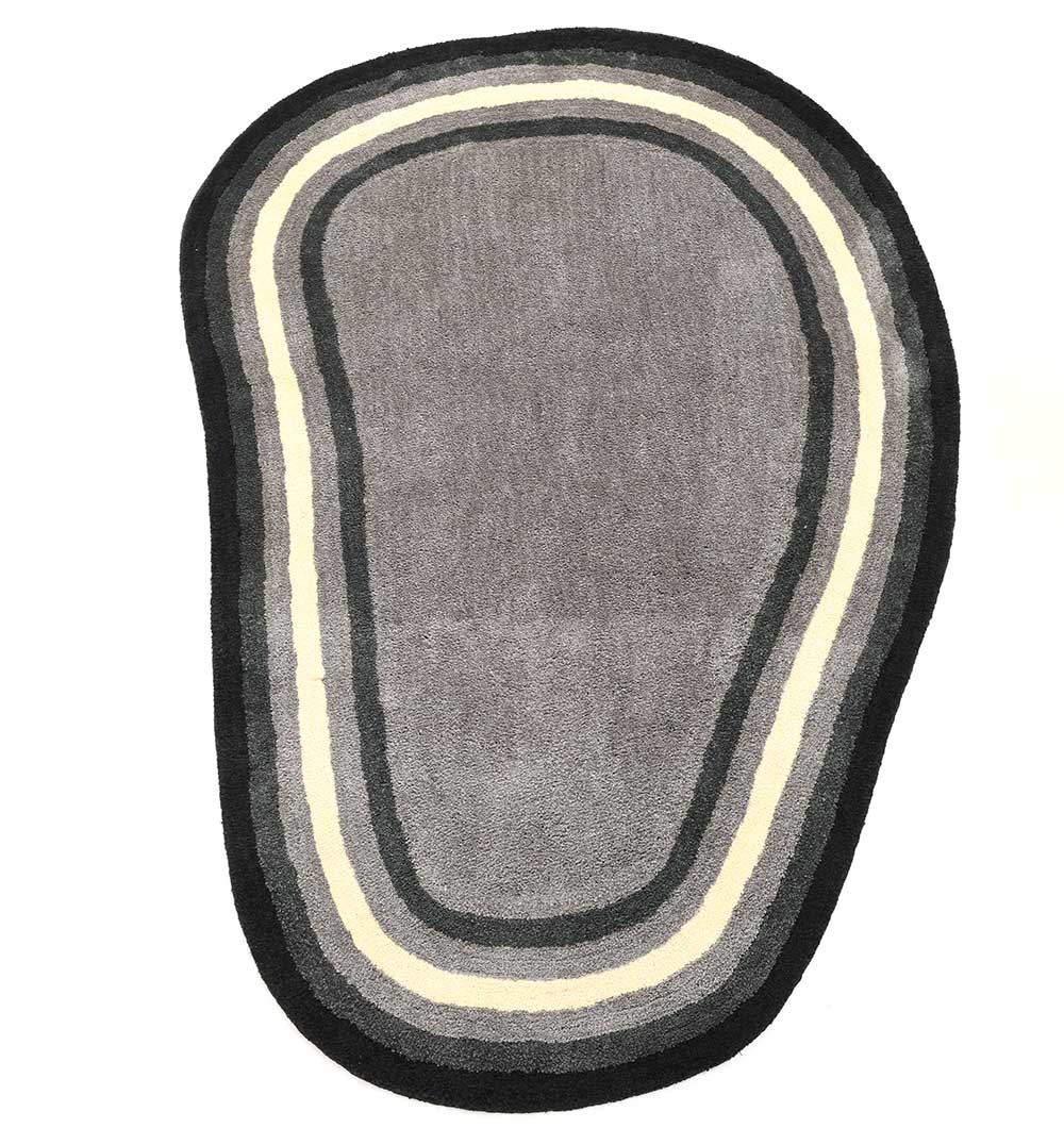 The RAMSHA HOME Shaggy Rug for Living Room - SG 037 (160x230 cm) features an irregular gray shape with organic edges and concentric black, gray, and cream outlines—a bold modern accent for contemporary spaces.