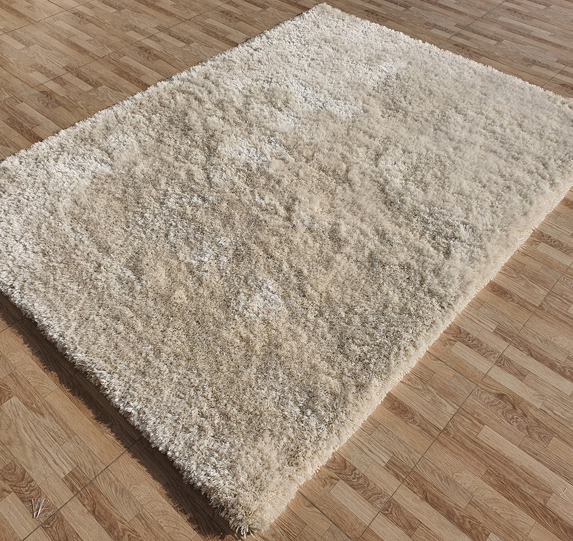 A RAMSHA HOME Gold Color Shaggy Area Rug for Large Living Room (SG 03 B) with plush fibers is placed on a light brown wooden floor with a square tile pattern, creating a cozy atmosphere.