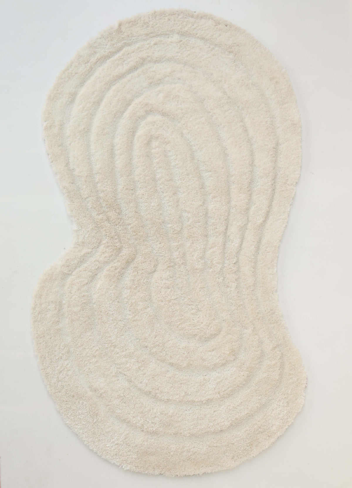 The RAMSHA HOME White Irregular Shaped Home Decor Shaggy Rug - SG 040 3D features a cream-colored, irregular silhouette with concentric textured lines reminiscent of topographic contours, displayed on a plain white surface.
