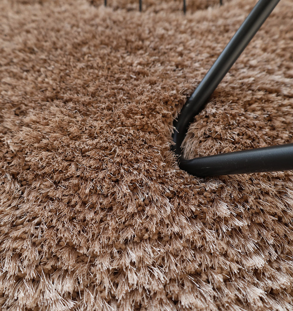 Close-up of black metal furniture legs on the RAMSHA HOME Soft Plush Brown Shaggy Rug for Living Room - SG 043, adding warmth and texture to the scene.