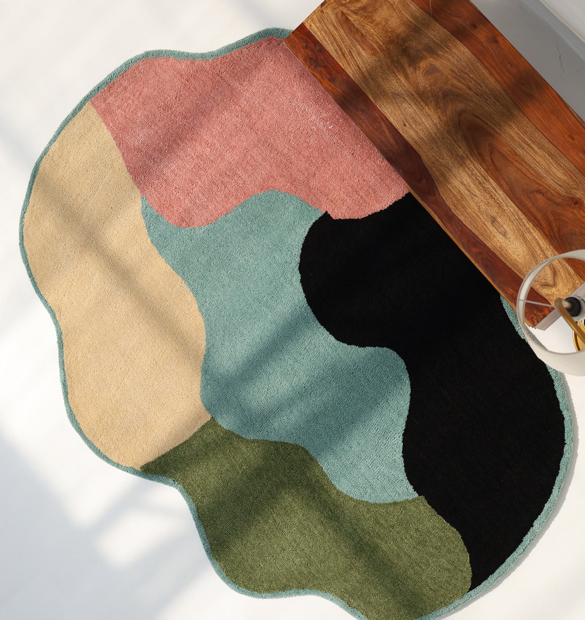 The RAMSHA HOME Modern Multicolor Irregular Soft Shaggy Carpet - SG 056, featuring wavy edges and abstract patterns in beige, pink, green, blue, and black, adds a cozy touch and contemporary flair to any space.
