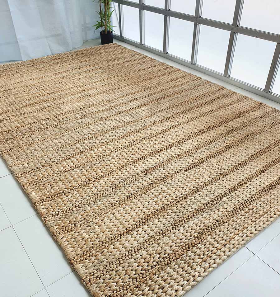 The RAMSHA HOME Natural Color Hand Woven Jute Rug SR-043, in a large rectangular size and natural beige, adds warmth and style to any space. Ideal as Ramadan gifts, this eco-friendly rug looks stunning on white tiled floors in bright rooms.