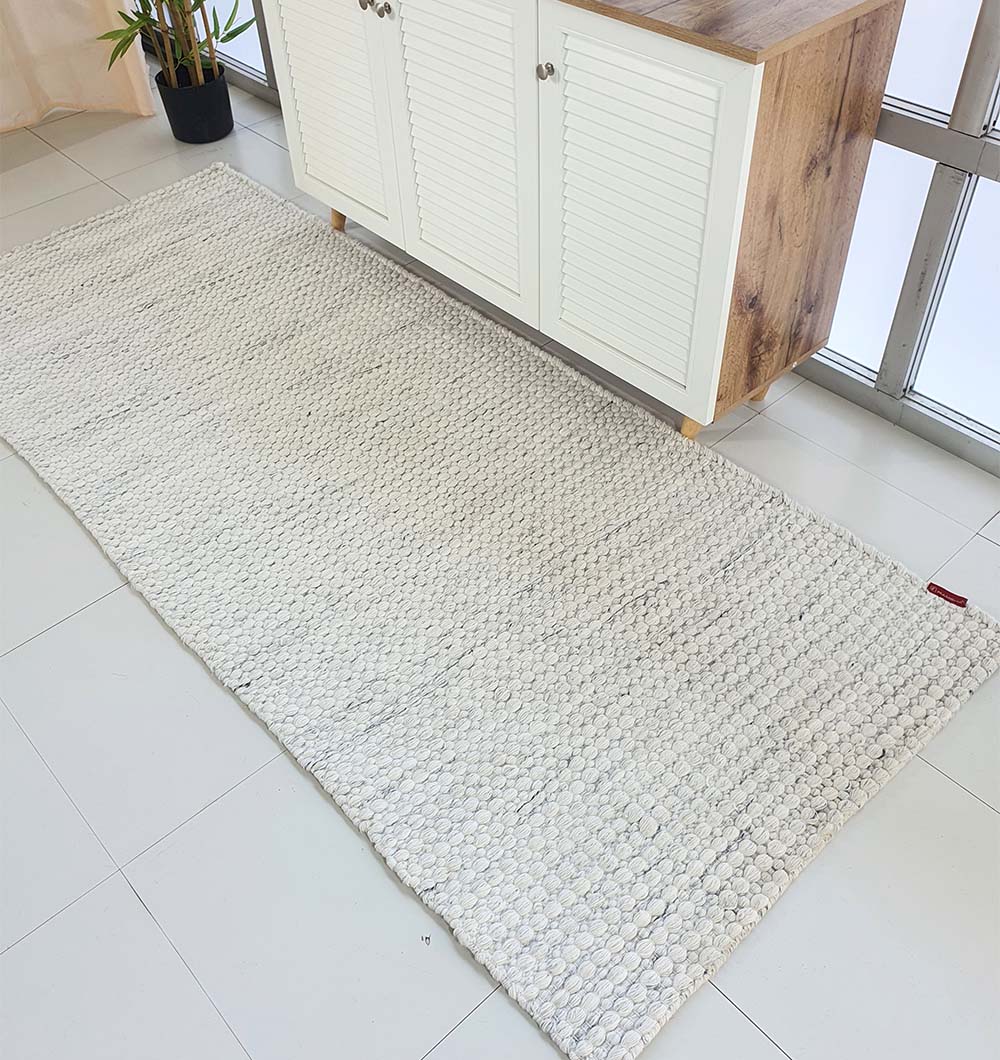 Natural white woven runner rug in a hallway, providing a versatile, sustainable, and durable choice for narrow spaces.