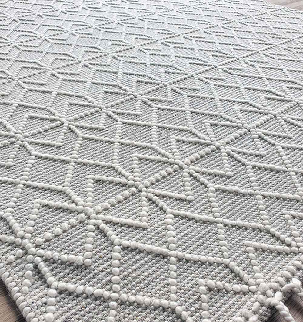 Close-up of the RAMSHA HOME Handmade Woven Rug SRN-007 in natural white, featuring a textured geometric pattern with raised dots and intersecting lines, plus fringes for added style.