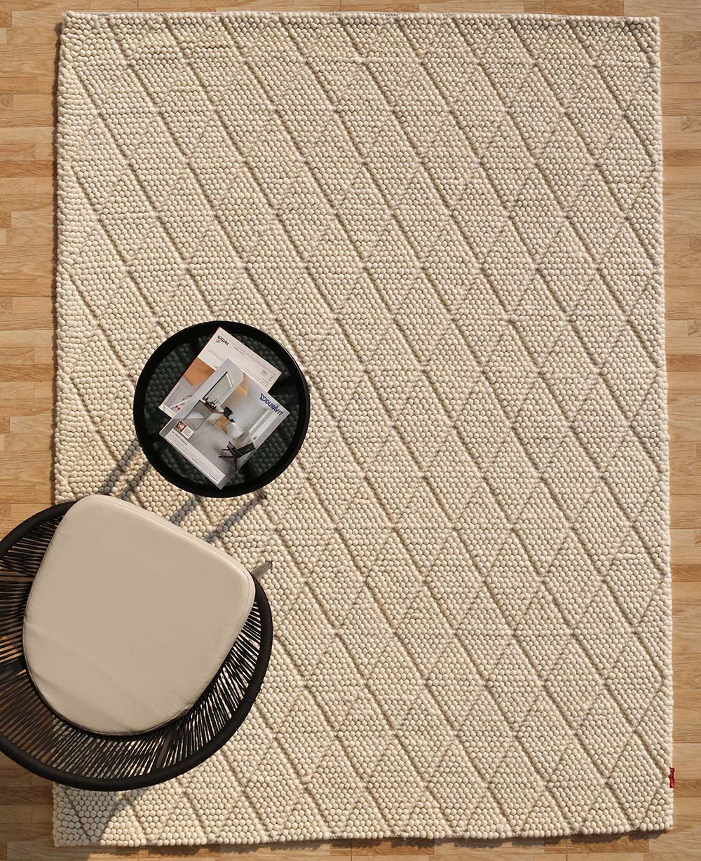 Hand-loomed wool and cotton area rug in a natural color palette, anchoring versatile interior design schemes.
