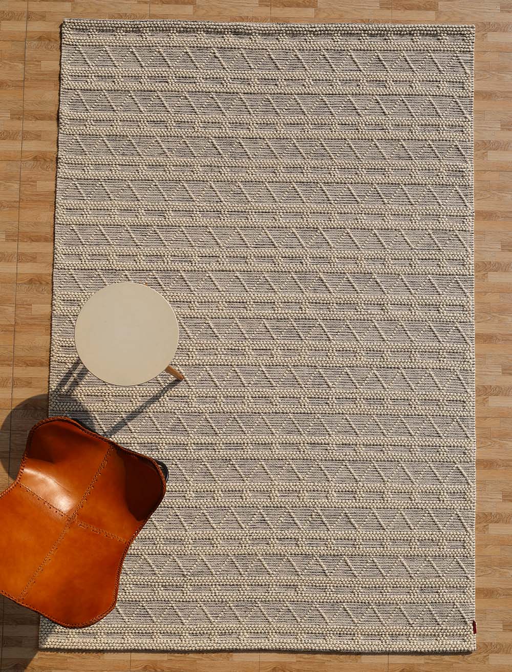 Handcrafted wool and cotton area rug in a natural color, bringing warmth and texture to the living space.