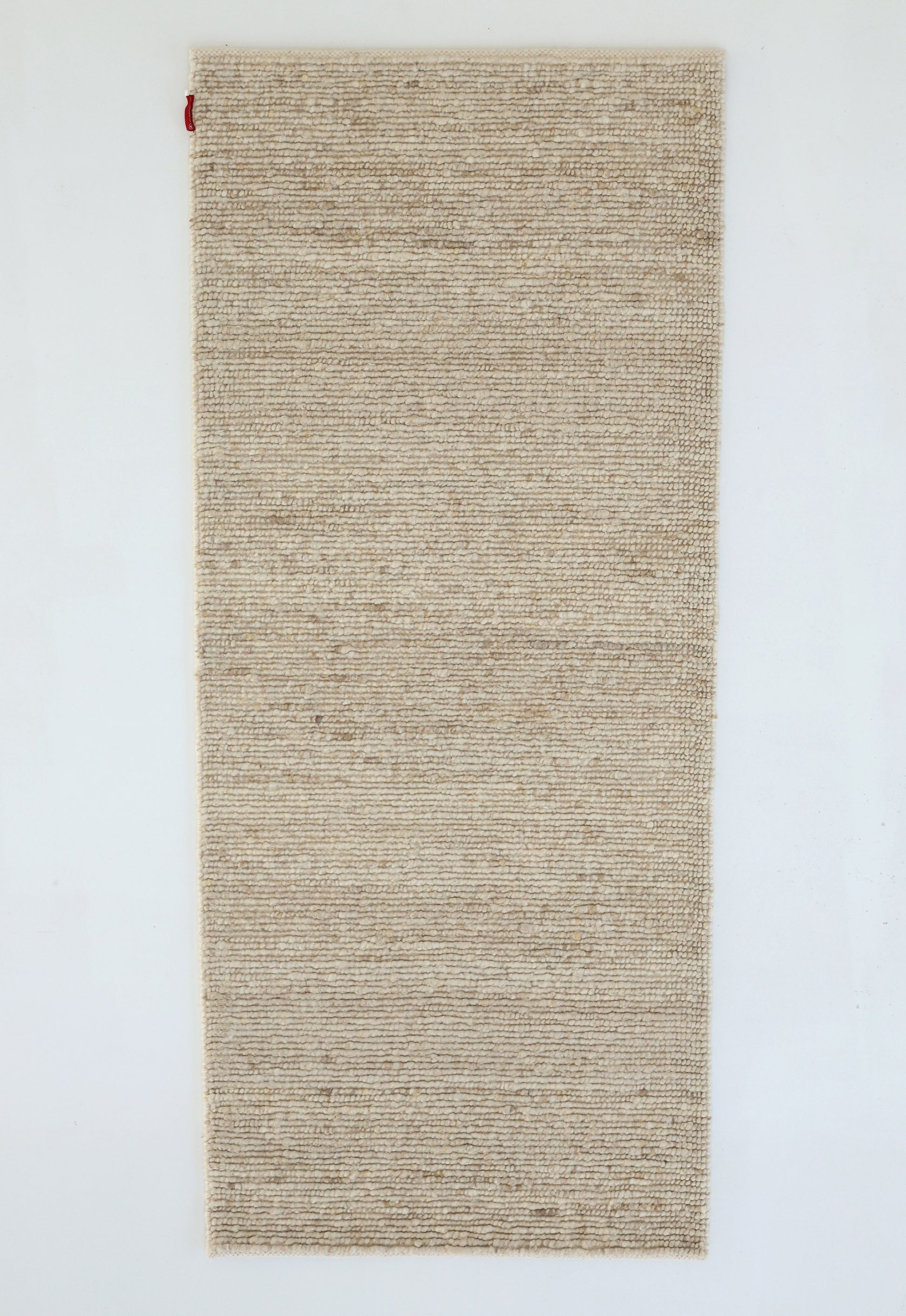 The RAMSHA HOME Earthy Blush Contemporary Flatweave Rug (SRN-044) is a rectangular, beige handmade piece with a subtle textured pattern and a small red fabric tag at the top left, reflecting traditional craftsmanship.