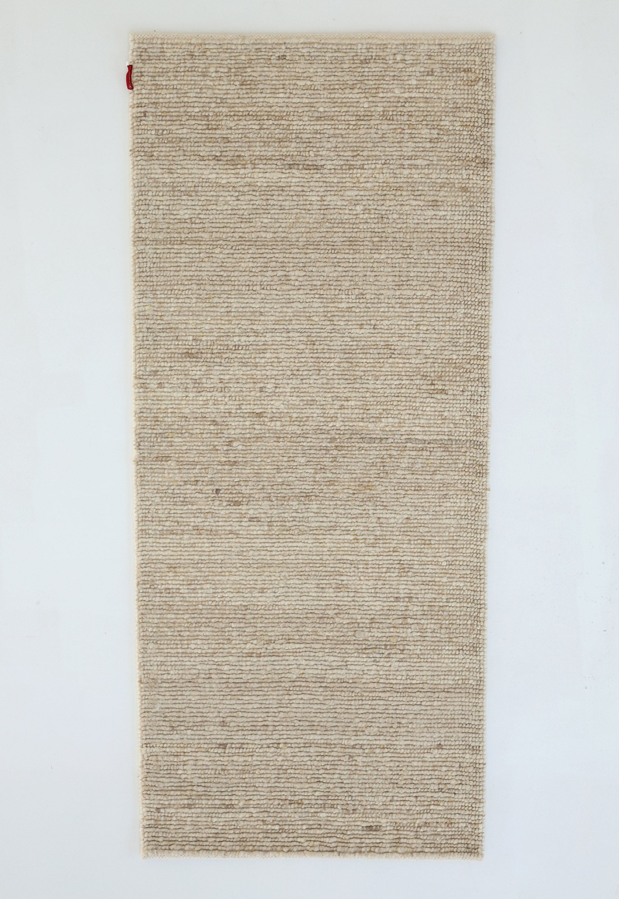 The RAMSHA HOME Earthy Blush Contemporary Flatweave Rug (SRN-044) is a rectangular, beige handmade piece with a subtle textured pattern and a small red fabric tag at the top left, reflecting traditional craftsmanship.