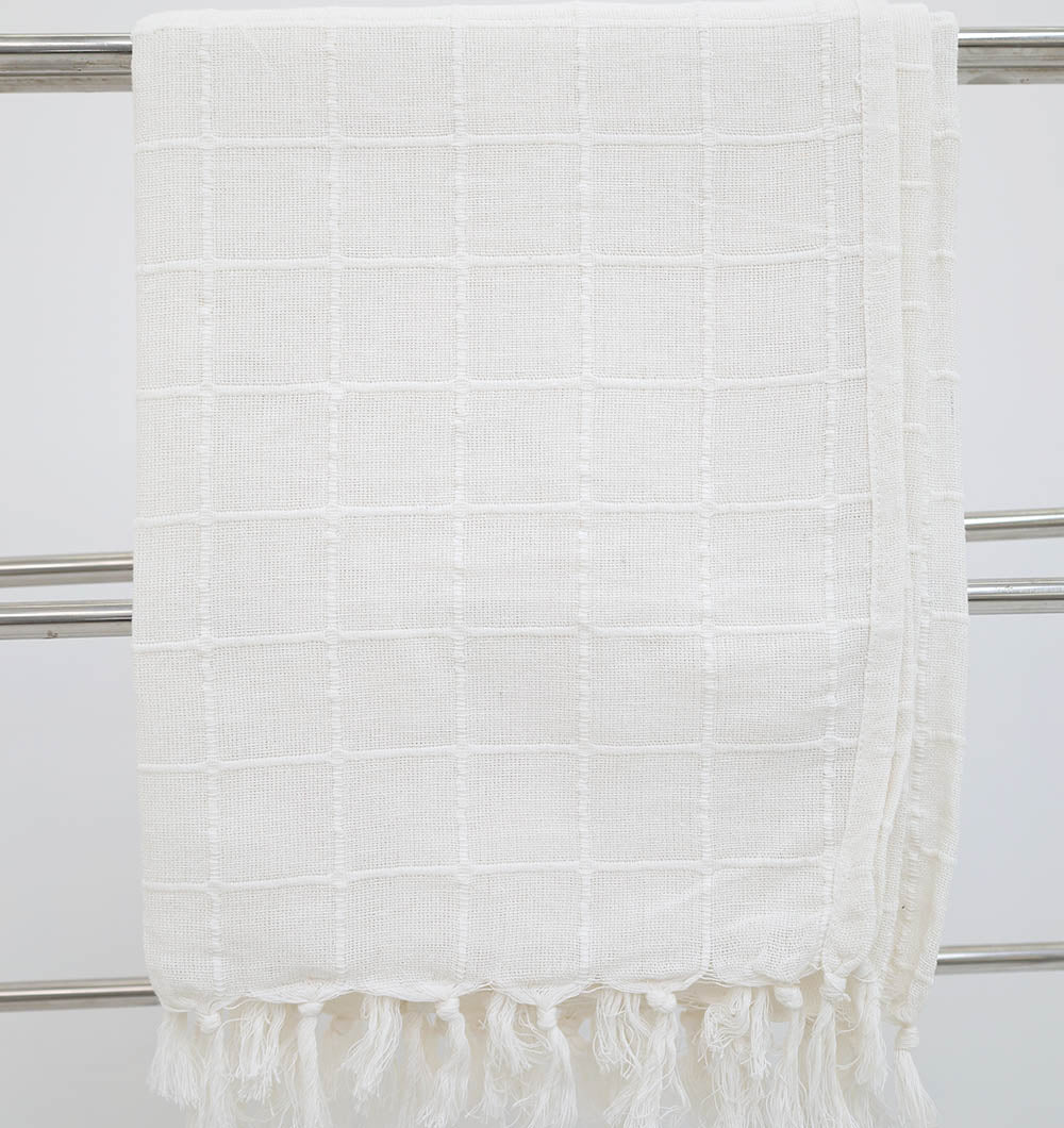 The White Decor Throw TAL 051 (130x160cm) by Ramsha Home drapes stylishly over a metallic towel rack, its textured checkered pattern and fringed tassels bringing modern comfort to the plain background.