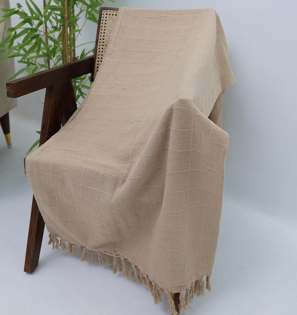 The Living Room Throw Beige Color TAL 052 (130x160cm) by Ramsha Home features a textured cotton grid pattern and fringed edges. Draped over a wooden chair, it adds a cozy, decorative touch—ideal for sofas or as an accent in any room.