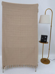 The Ramsha Home Living Room Throw Beige Color TAL 052 (130x160cm) with a grid pattern and fringe hangs over a stand near a gold floor lamp with a round shelf, where a black flip clock shows 08:53 against the white background.